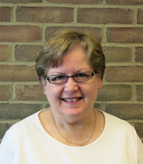 woman in front of brick wall with cream shirt