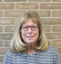 woman in front of brick wall with blue and white striped shirt